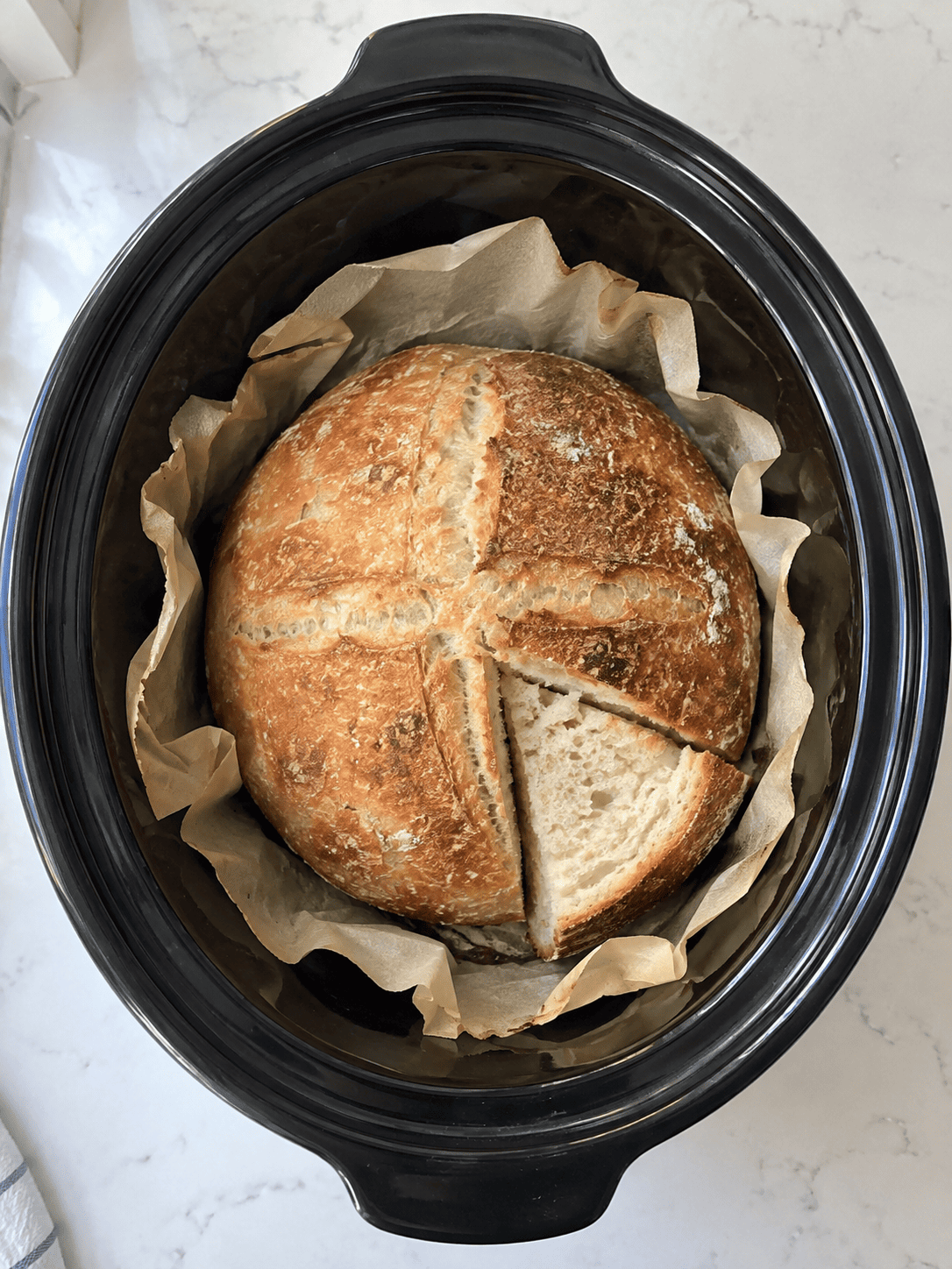 Crock Pot Bread viewed from above in a parchment-lined slow cooker