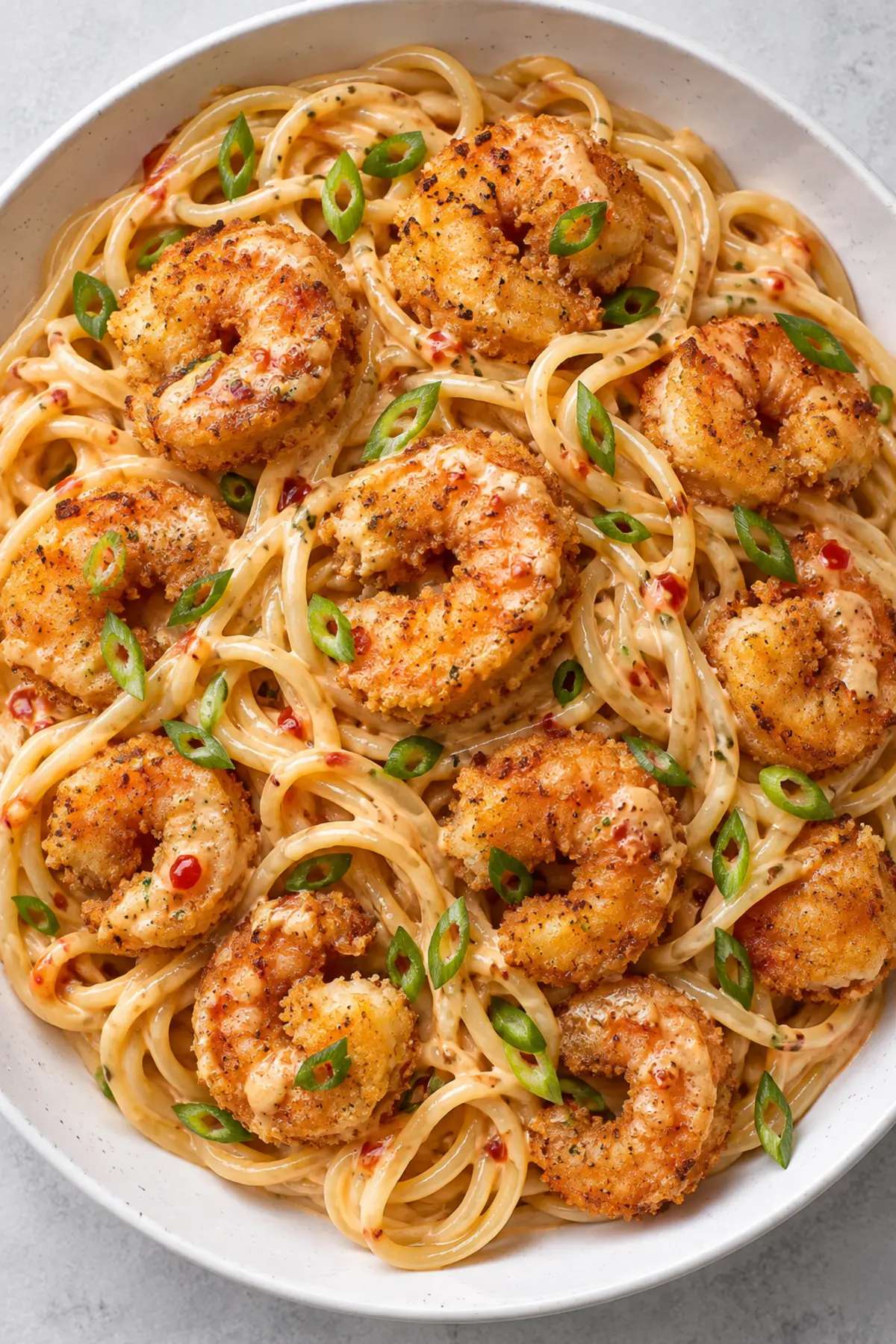 Overhead view of Bang Bang Shrimp Pasta with crispy shrimp and sliced scallions