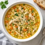 Italian Penicillin Soup recipe with stelline pasta, shredded chicken, vegetables, parsley, and Parmesan
